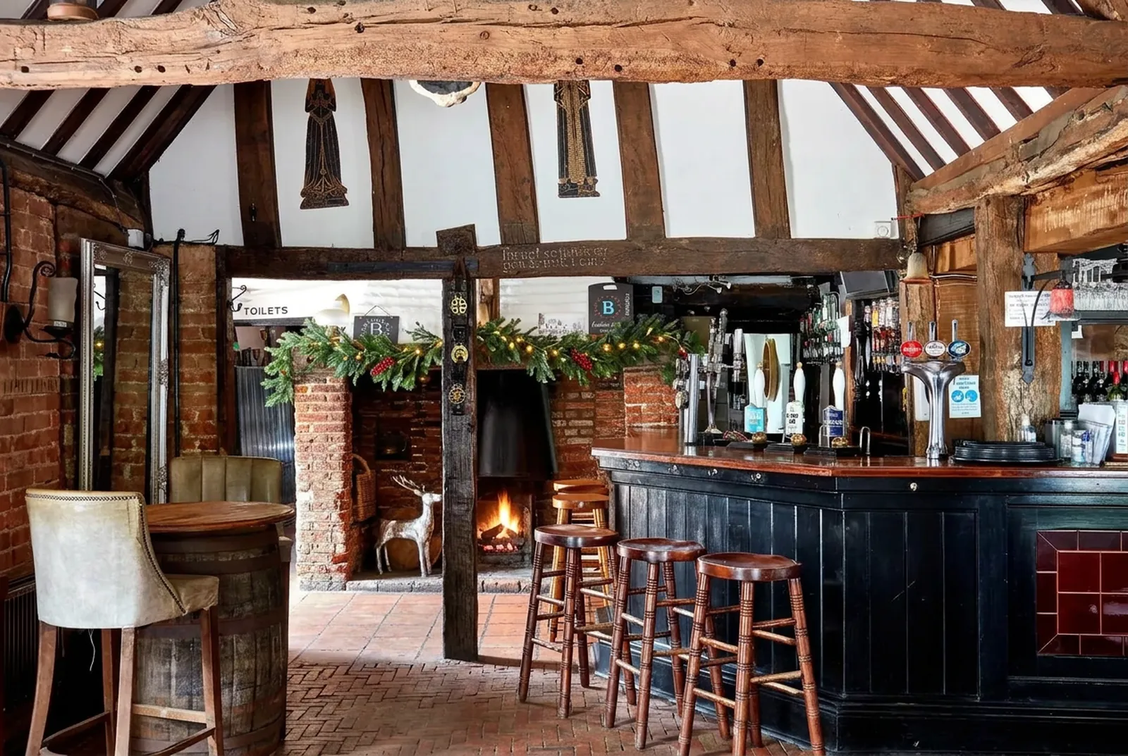 The Horns fireplace with subtle Christmas greenery and warm lights, a seasonal edit of the pub photograph