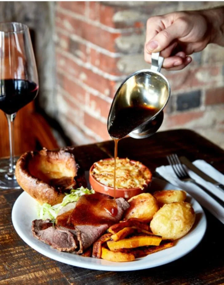 Gravy poured over a Sunday roast at The Horns