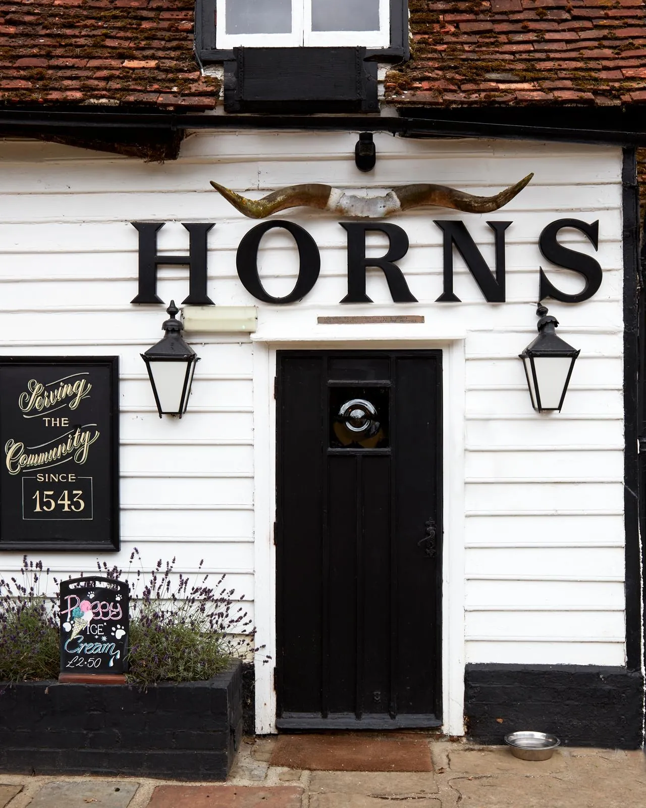 The front door and pub sign at The Horns